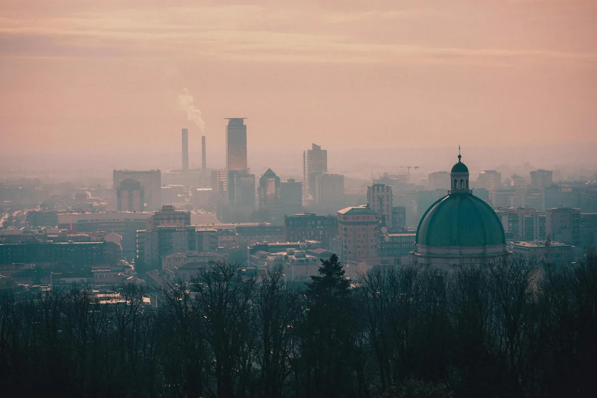 A city skyline visible through hazy orange wildfire smoke.