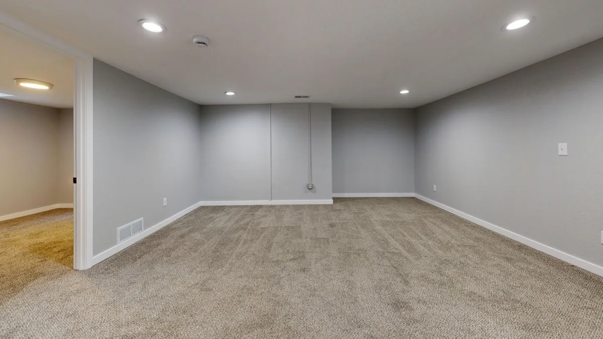 A residential basement with a furnace, water heater, dehumidifier, and stored boxes against a foundation wall, with a Terrestream sensor on a workbench.