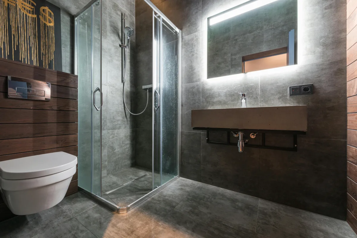 Steam rising in a brightly lit bathroom with a glass shower door.