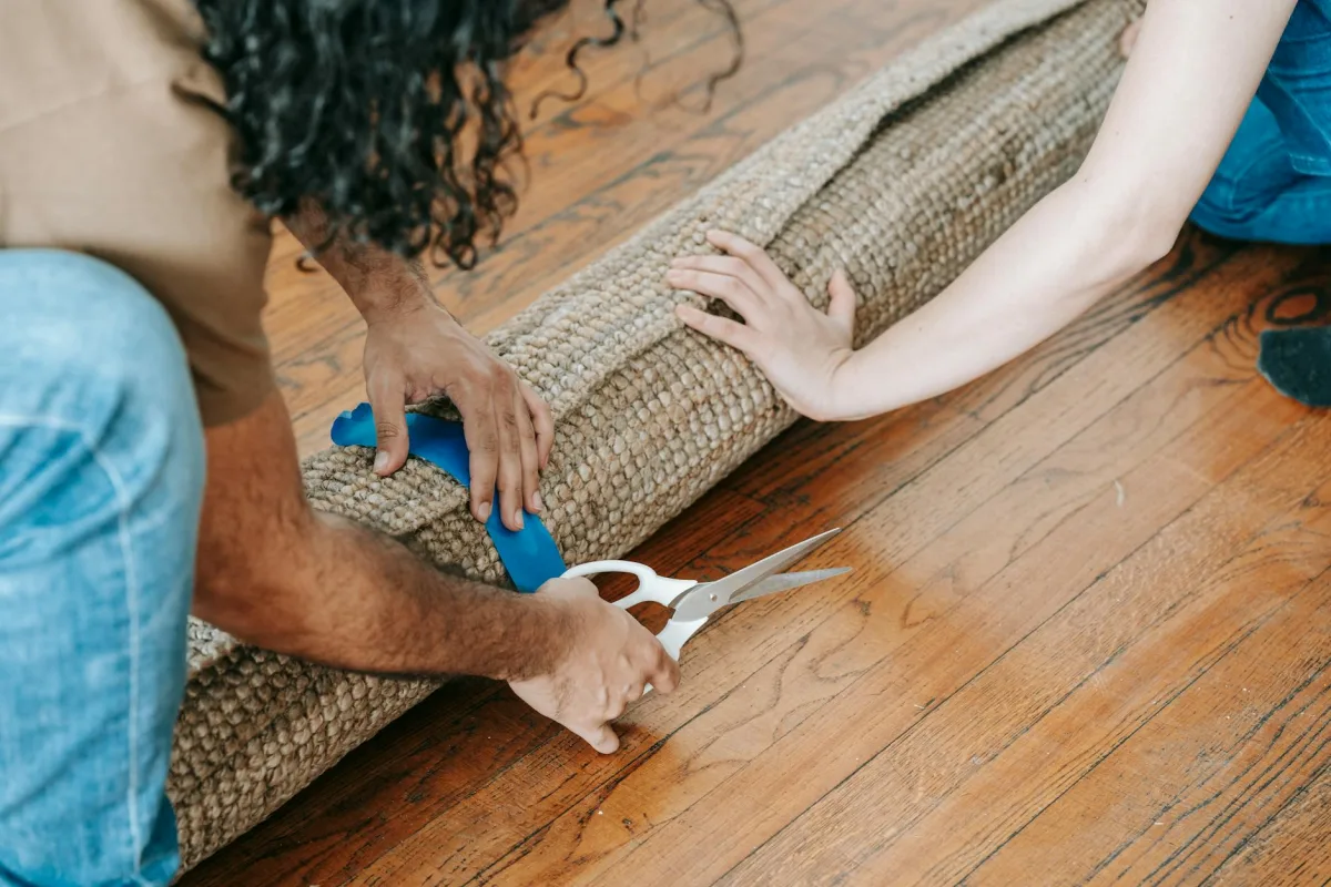 Side-by-side floor sections: a low-pile carpet, a hardwood plank, a tile square, and a luxury-vinyl plank, labeled with VOC and dust profiles.