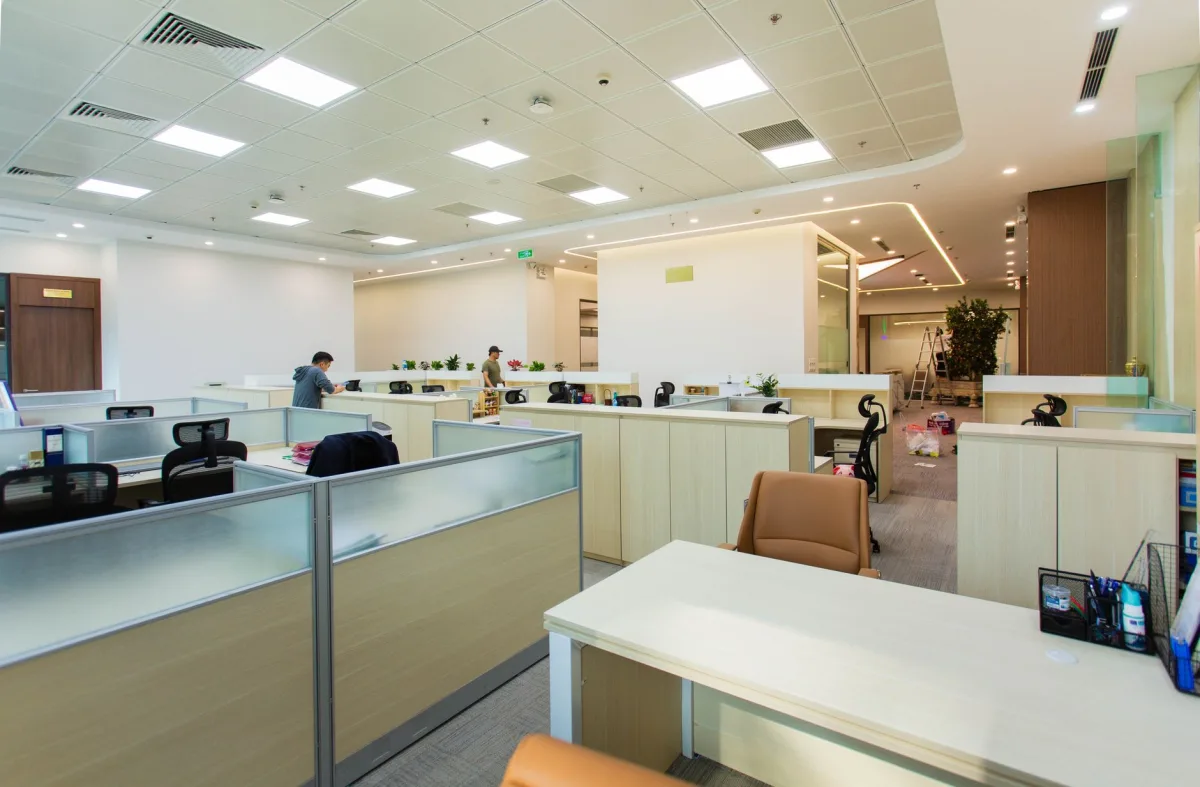 A modern open-plan office workspace with desks, monitors, and large windows - the kind of multi-room environment a central-dashboard deployment is designed for.