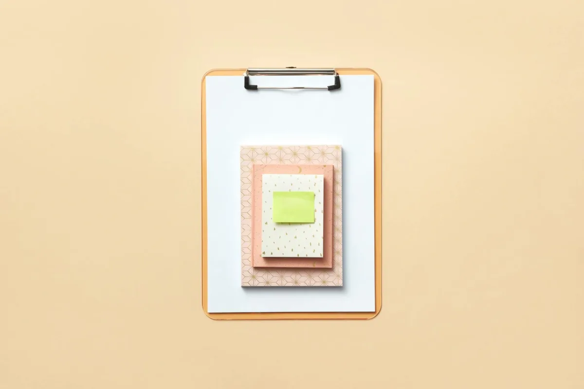 A clipboard with a checklist resting on a desk in a school classroom.