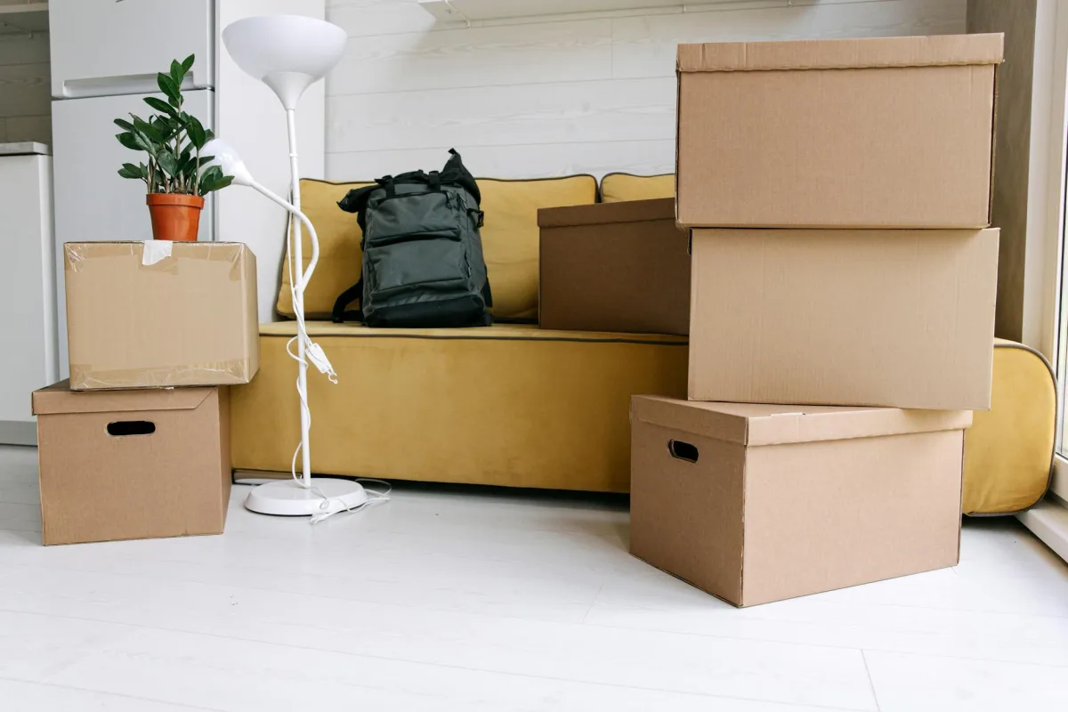 Cardboard moving boxes in a partially-furnished living room.