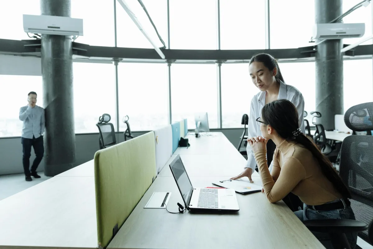An open-plan office in late afternoon with a glass-walled conference room in the background and a Terrestream sensor on a desk.