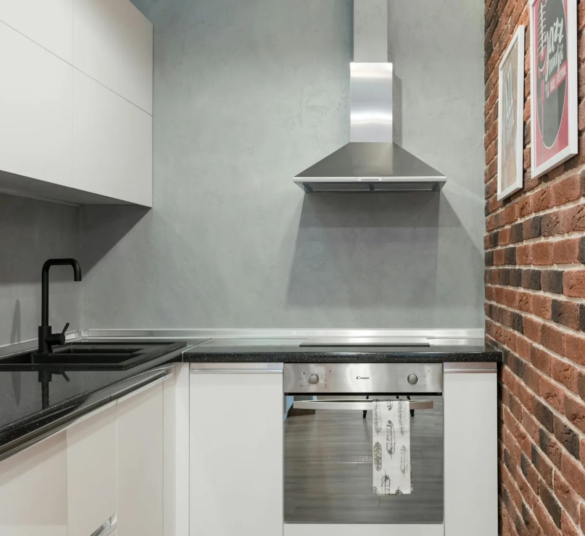 A range hood photographed from below, blue gas flame visible on the cooktop beneath.