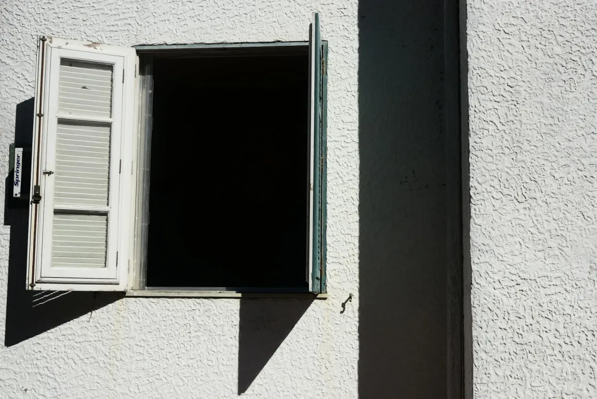 A home on a hot summer afternoon with windows closed and the HVAC running, a Terrestream sensor showing low indoor ozone next to an AirNow alert on a phone.