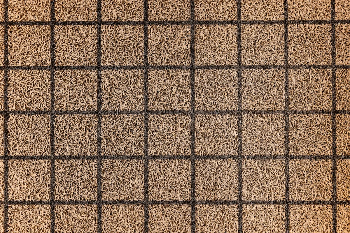 An entryway with walk-off mats and a HEPA-filtered vacuum, with a Terrestream sensor on a side table.