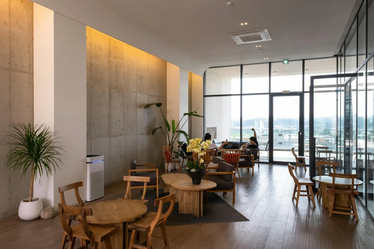 A living room with a portable HEPA purifier running, a MERV-13 filter visible at the HVAC return, and a Terrestream sensor showing low PM2.5.