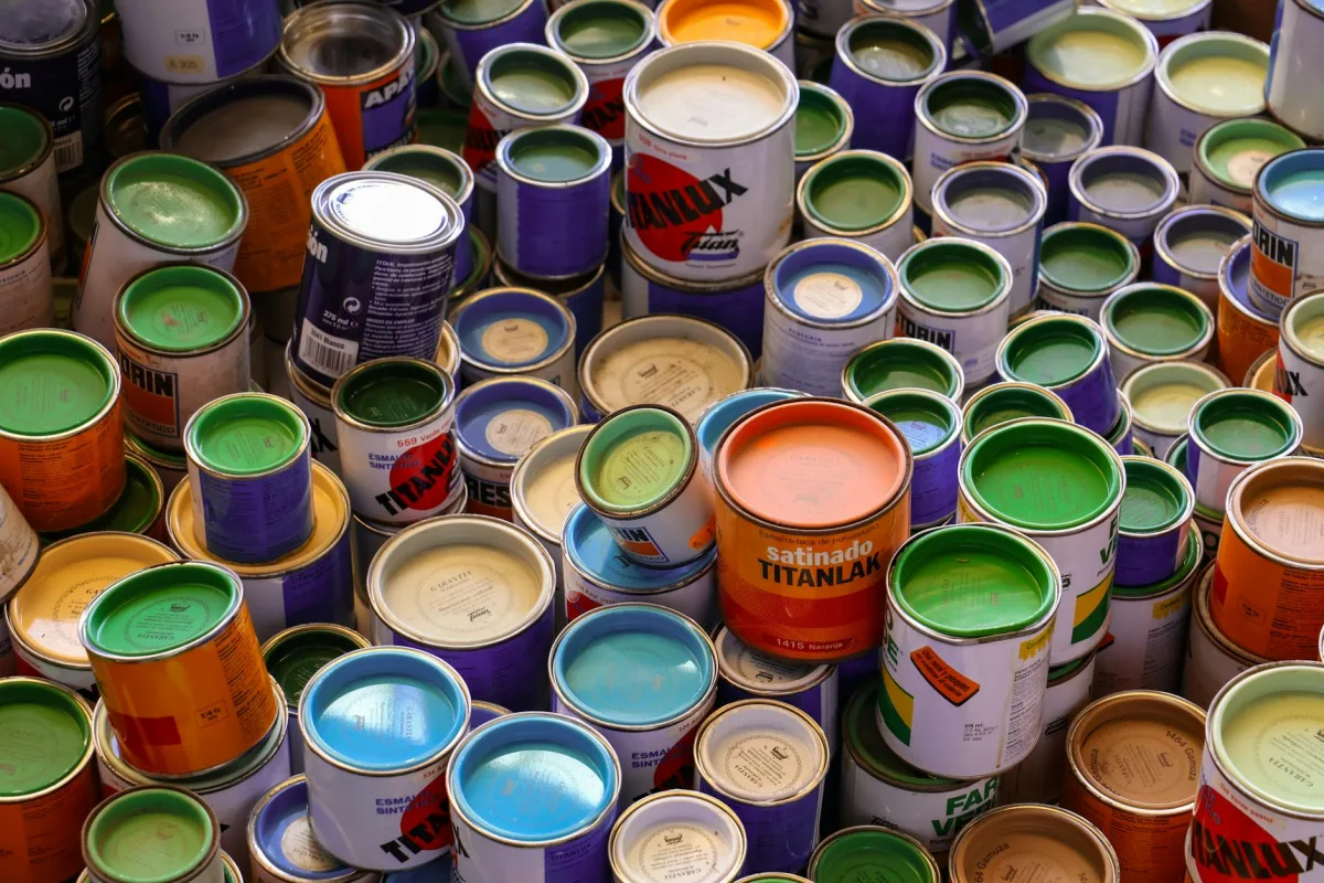 A homeowner choosing a low-VOC paint at a hardware store, with the third-party certification label visible on the can.