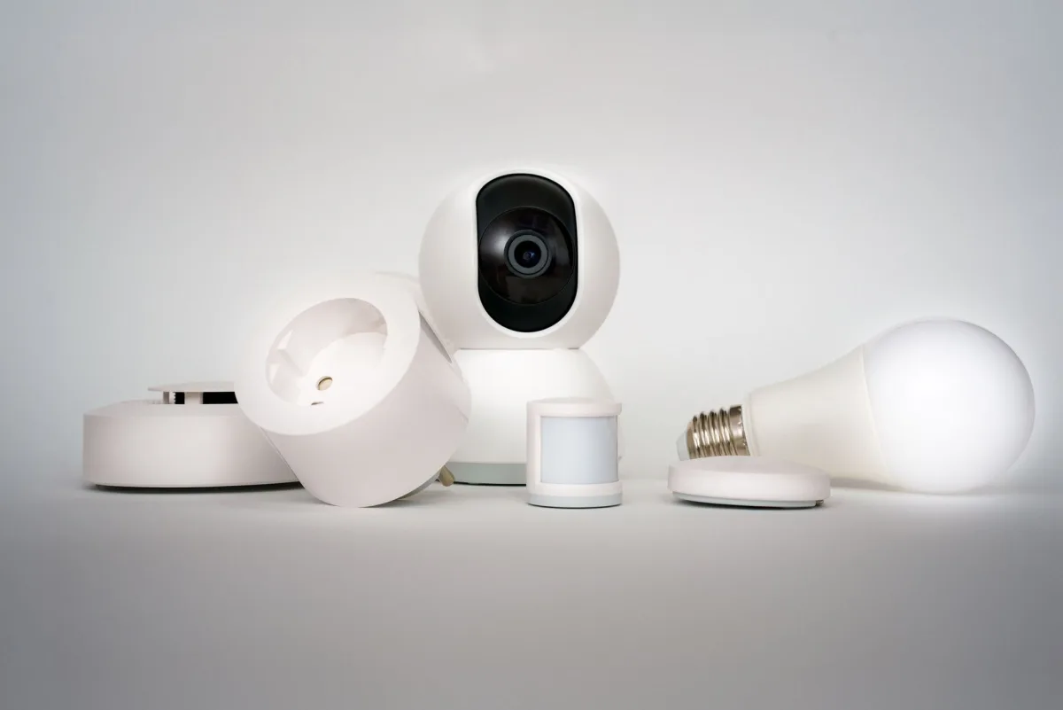 A residential smoke alarm mounted on a hallway ceiling, with a Terrestream sensor visible on a side table below.