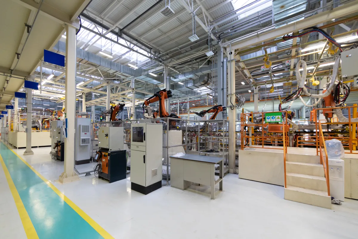 Industrial facility with overhead lighting, racks, and concrete floor